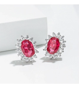 Macro detail of oval pink sapphire stud earrings with white zircon halo in silver setting