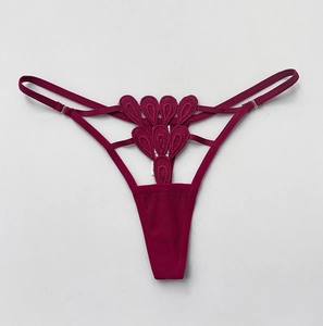 Detailed embroidery and lace cutout texture on burgundy low-rise adjustable thong