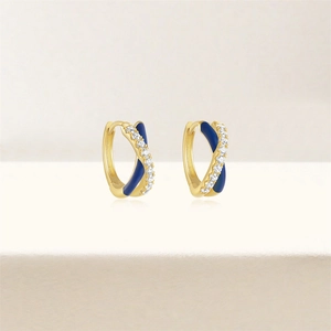 Macro shot of gold-plated crossover hoop earrings with blue enamel and pavé zircons