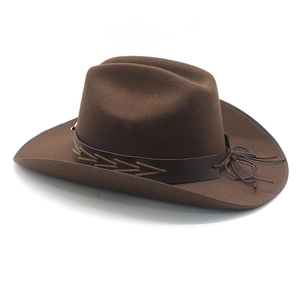 Detail of dark brown wool felt cowboy hat featuring woven leather band and tassel accents