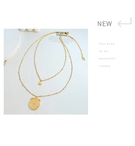 Detail of double-layer gold star and coin pendant necklace with sparkling zircon