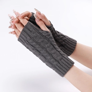 Detail of dark grey cable knit fingerless gloves showing warmth and soft texture on hand