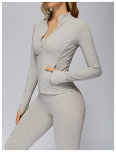 Detail of grey athletic zip jacket featuring thumbholes and functional side pockets