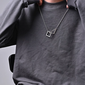Close-up of minimalist titanium steel necklace with geometric square and triangle pendants