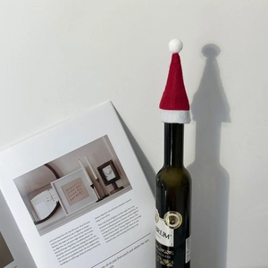 Mini red felt Christmas hat for wine bottles with soft white pompom and plush trim detail