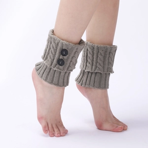 Detail view of grey knit leg warmers with cable stitch pattern and double button accents