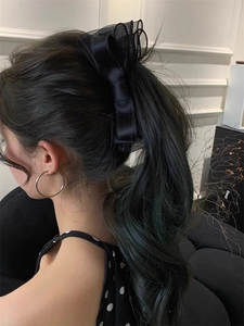 Detail of elegant black double-layered mesh bow banana clip worn on hair for a sweet look