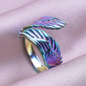 Macro shot of iridescent rainbow wing ring on soft purple silk fabric background
