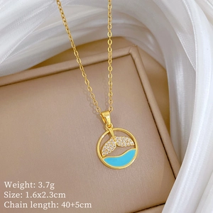 Detail view of fishtail pendant with sparkling crystals and turquoise inlay on gold chain