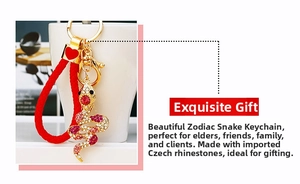 Detailed view of snake keychain with sparkling red crystals and festive red braided rope