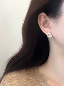 Close-up of gold gourd stud earring with zircon on a model for an elegant look