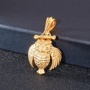 Macro detail of golden hip-hop owl pendant showing intricate feather texture and metallic sheen