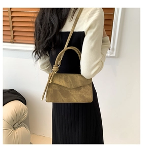 Vue détaillée d'un sac bandoulière vintage en daim marron avec poignée nouée