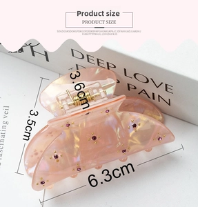 Detailed view of a pink iridescent 6.3cm hair claw clip with purple rhinestones