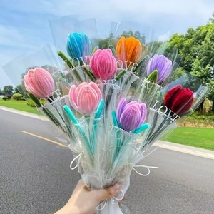 Handmade crochet tulip bouquet with colorful wool flowers and lace wrap in outdoor setting
