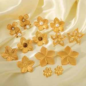 Textured 18K gold plated flower and star stud earrings on cream silk fabric base