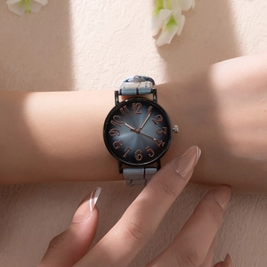 Detail of blue sunray dial watch with rose gold numerals and light blue textured strap