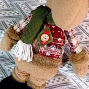 Detail der Weihnachts-Plüschfigur mit rotem Karomuster und grünem Strickschal-Stoff