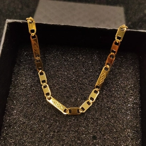 Macro view of 18K gold plated stainless steel rectangle links with geometric diamond patterns