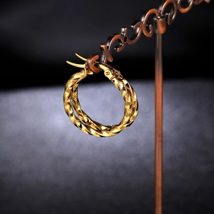 Macro shot of twisted gold hoop earrings with textured finish and secure latch back