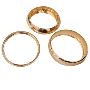 Three-piece set of polished golden geometric bangles in a minimalist metallic style