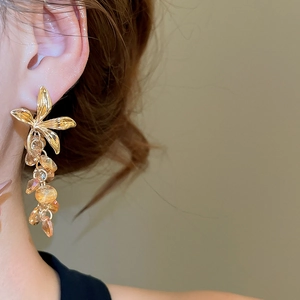 Détail de boucles d'oreilles fleur à pampilles en cristal champagne et métal doré