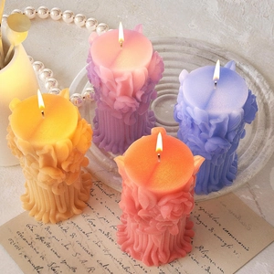 Detailed view of four carved rose pillar candles in yellow, pink, violet and coral red