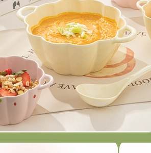 Detail of yellow pumpkin ceramic soup bowl with matching spoon and cereal display