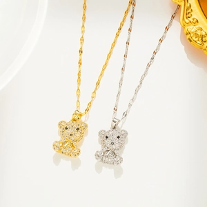 Close-up of gold and silver bear pendants with pavé zircon crystals on thin chains