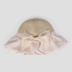 Dettaglio cappello da sole elegante in paglia kaki con tesa beige e grande fiocco