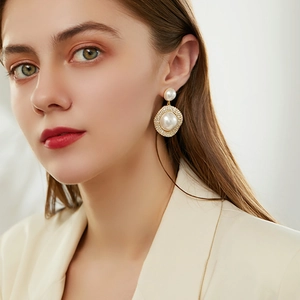 Elegant gold earrings with large round pearls and sparkling diamond-set circular frames