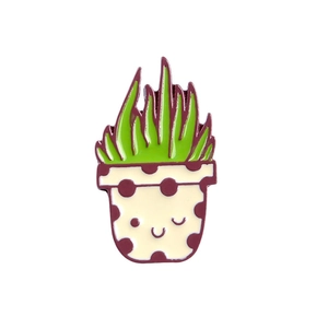 Macro view of cute cartoon cactus enamel pin in a pot with vibrant green and brown colors