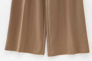 Close-up showing the fine stitching and fabric texture of dark brown wide-leg pants