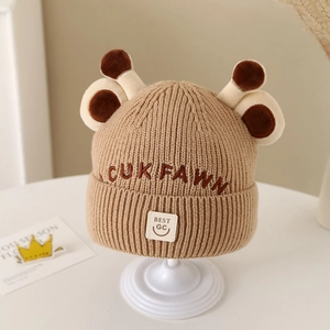 Detailed close-up of chunky knit baby hat with 3D deer antlers and embroidered patches