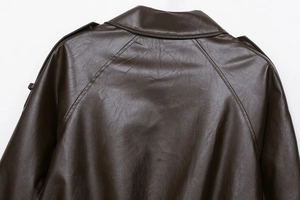 Detail of dark brown faux leather bomber jacket showing shoulder stitching and collar texture