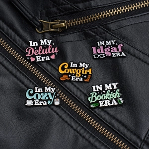 Set of five colorful enamel letter pins with trendy slogans on a black leather jacket