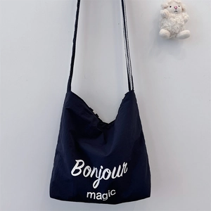 Deep blue canvas tote bag detail showing Bonjour magic print and white lamb charm