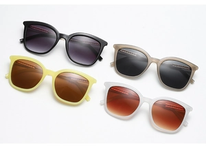 Flat lay of retro square sunglasses in black, grey, yellow, and white frames with metal details