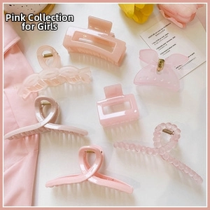Flat lay of diverse pink acrylic hair claw clips in various shapes on a soft aesthetic backdrop