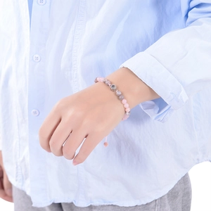 Pink zebra stone bracelet with personalized photo projection charm on a model's wrist