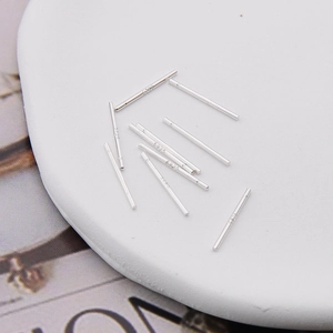 Multiple S925 sterling silver ear studs and pins displayed on a white round cushion