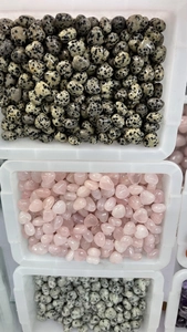Bulk display of assorted 15mm heart-shaped natural crystal stones in white plastic trays