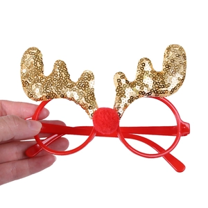 Detail of red Christmas glasses with gold sequin reindeer antlers on white background