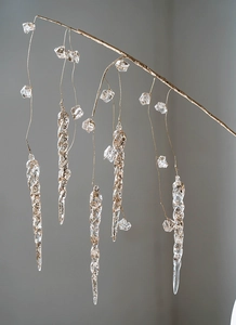 Macro view of transparent acrylic icicle ornaments with gold glitter and sequins