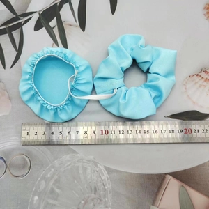 Detail view of blue elastic drink cover scrunchie set with measuring ruler on white tray