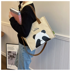Detailed shoulder view of a beige canvas panda tote bag for daily commuting