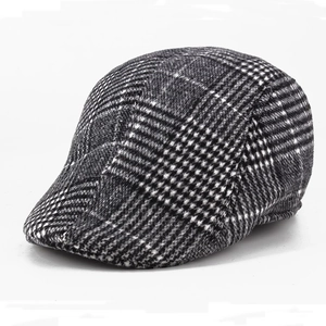 Classic black and white houndstooth plaid newsboy cap in warm wool fabric texture