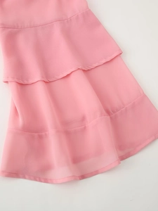 Close-up of pink chiffon fabric layers and ruffled hem on a bohemian style top