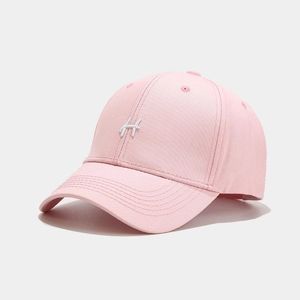 Dettaglio del cappellino rosa con lettera H ricamata bianca e fori di ventilazione