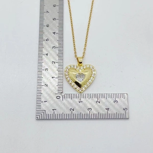 Gold heart pendant necklace with colorful zircons and metal ruler showing dimensions